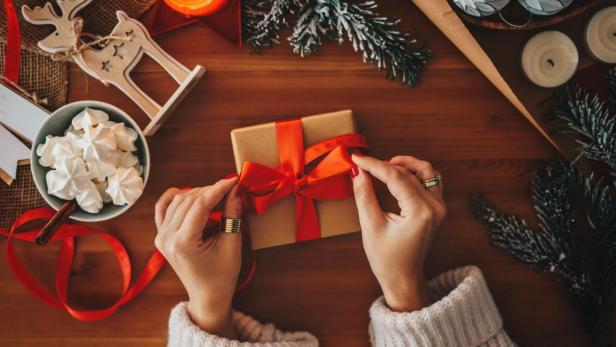 Eine Frau verpackt Weihnachtsgeschenke, Draufsicht.
