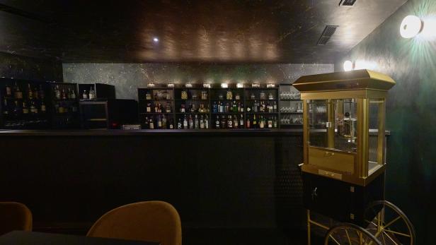 Eine Bar mit einer goldenen Popcornmaschine auf Rädern.