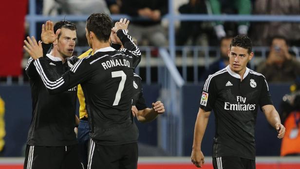 Die Fußballspieler Gareth Bale, Cristiano Ronaldo und James Rodríguez in schwarzen Trikots auf dem Spielfeld.