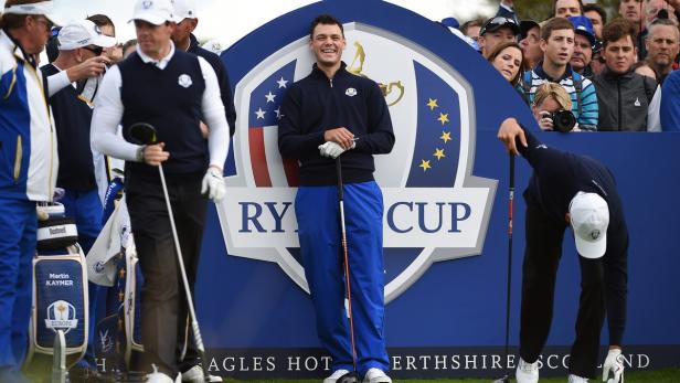 Golfspieler posieren vor dem Ryder Cup Logo.