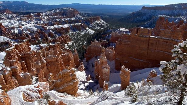 Winterliche Landschaft im Bryce-Canyon-Nationalpark mit schneebedeckten Felsformationen.