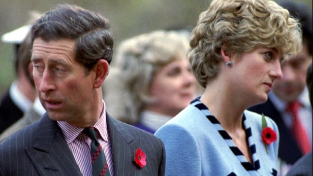 FILE PHOTO: Princess Diana and Prince Charles look in different directions, November 3, during a service