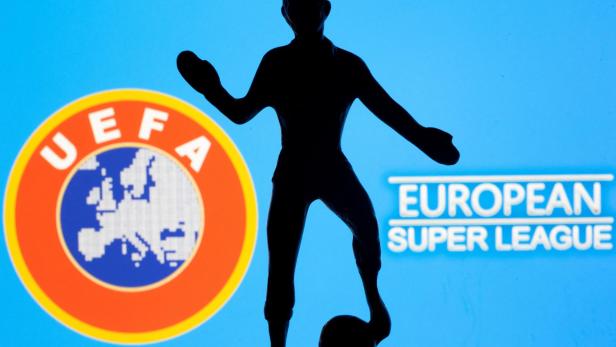 FILE PHOTO: A metal figure of a football player with a ball is seen in front of the words "European Super League" and the UEFA logo in this illustration