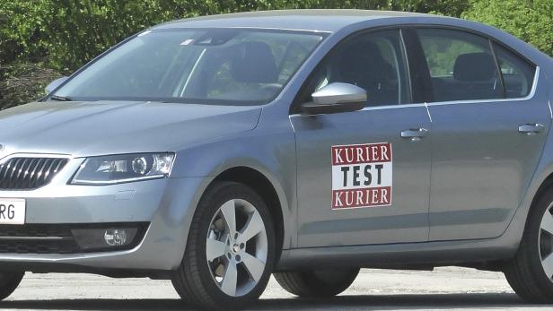 Ein grauer Škoda Octavia mit einem „Kurier Test Kurier“-Aufkleber auf der Tür.