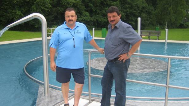 Zwei Männer stehen am Beckenrand eines Schwimmbads.