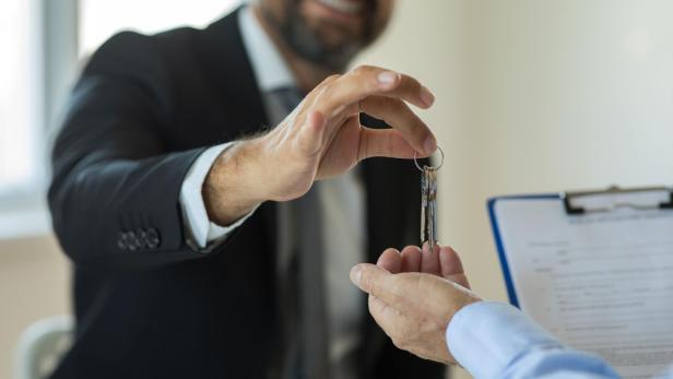 Realtor hand giving keys to new house owner