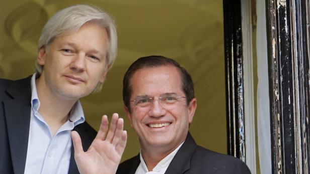 WikiLeaks founder Julian Assange waves from a window with Ecuador&#039;s Foreign Affairs Minister Ricardo Patino (R) at Ecuador&#039;s embassy in central London June 16, 2013. Assange sought asylum in the embassy on June 19, 2012, in an attempt to avoid extradition to Sweden. REUTERS/Chris Helgren (BRITAIN - Tags: POLITICS MEDIA CRIME LAW TPX IMAGES OF THE DAY)