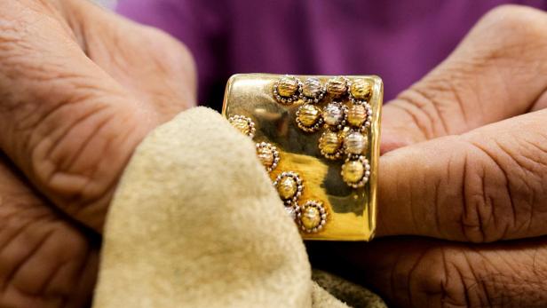 FILE PHOTO: A gold vendor polishes a golden piece inside a shop at the gold market area in Cairo