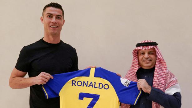 Portuguese soccer player Cristiano Ronaldo holds a shirt of the Saudi club Al-Nassr after signing the contract