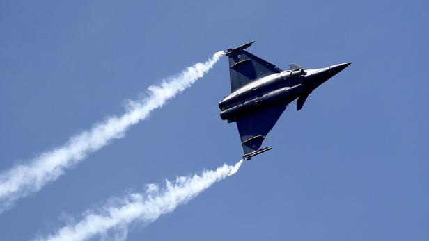 Ein Kampfjet zieht Kondensstreifen vor einem blauen Himmel.