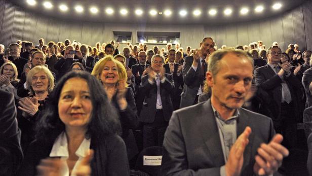 Ein Publikum applaudiert in einem Kinosaal.