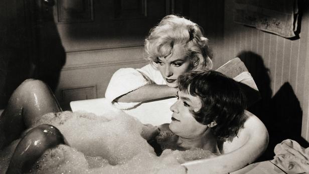 Marilyn Monroe schaut zu, wie eine Frau in einer mit Schaum gefüllten Badewanne liegt.
