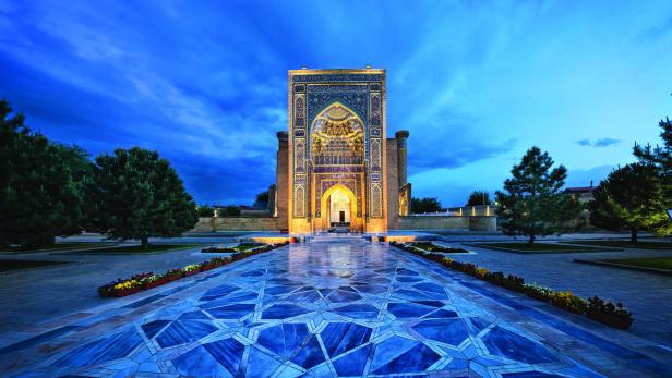 Der kunstvoll verzierte Eingangsbereich einer Moschee in Samarkand bei Dämmerung.