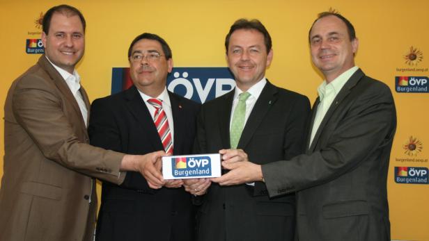 Vier Männer im Anzug präsentieren ein Schild mit dem Logo der ÖVP Burgenland.