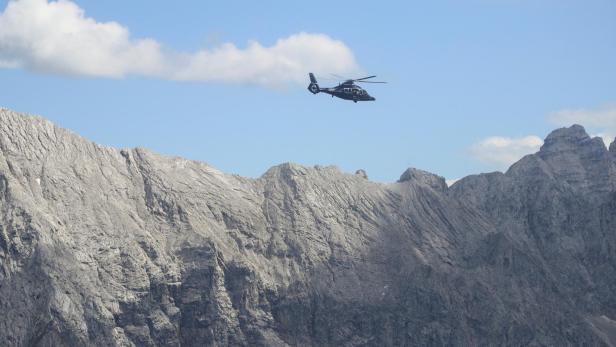 A helicopter of German federal police Bundespolizei flies over the Wetterstein Alpine mountains near hotel Castle Elmau