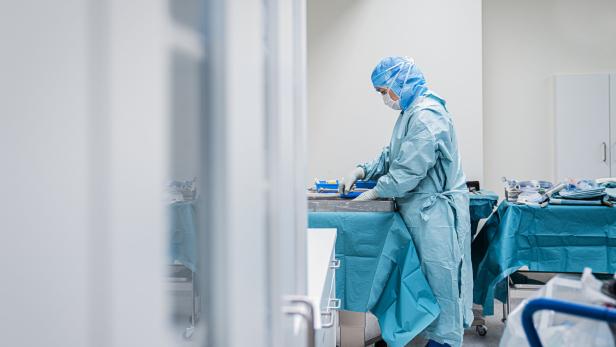 Eine Frau in OP-Kleidung bereitet Instrumente für eine Operation vor.