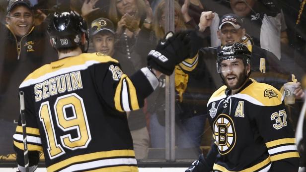 Boston Bruins center Patrice Bergeron (R) celebrates his second period goal against the Chicago Blackhawks with teammate Tyler Seguin (19) during Game 3 of their NHL Stanley Cup Finals hockey series in Boston, Massachusetts, June 17, 2013. REUTERS/Winslow Townson (UNITED STATES - Tags: SPORT ICE HOCKEY)