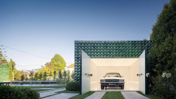 Die Casa AD25 in Lissabon ist ein Einfamilienhaus, das mit grün glasierten Ziegeln verkleidet wurde. Garagenkubus von João Tiaga Aguiar Arquitectos Garagenkubus