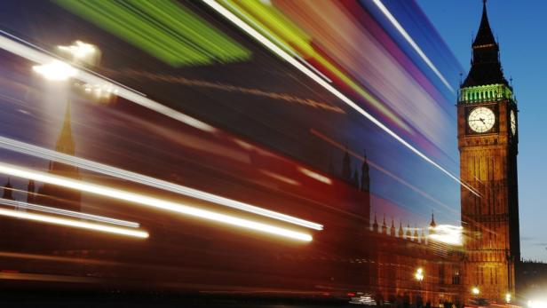 Der Big Ben in London mit Lichtstreifen vorbeifahrender Fahrzeuge im Vordergrund.