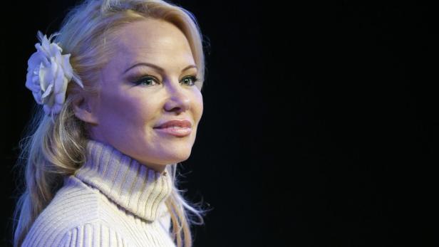Pamela Anderson mit einer weißen Blume im Haar.