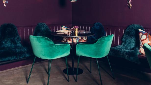 Ein Speisezimmer in Lila und Grün mit ungewöhnlicher Dekoration.