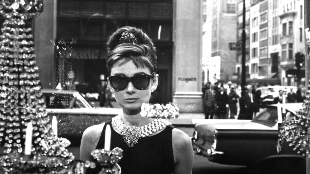 Audrey Hepburn als Holly Golightly in „Frühstück bei Tiffany“ vor einem Juweliergeschäft.