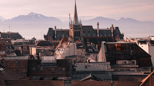 Blick über die Dächer von Lausanne mit den Alpen im Hintergrund.