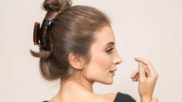 Eine Frau mit braunen Haaren trägt eine Haarspange.