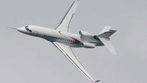 Ein weißes Flugzeug, möglicherweise ein Privatjet, fliegt in den Himmel.