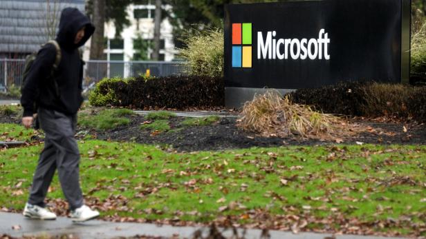 A person walks past Microsoft signage at the headquarters in Redmond