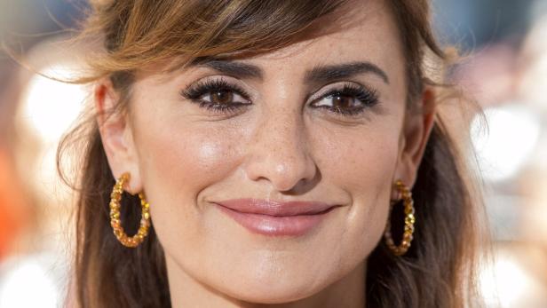 Nahaufnahme von Penélope Cruz mit goldenen Ohrringen.