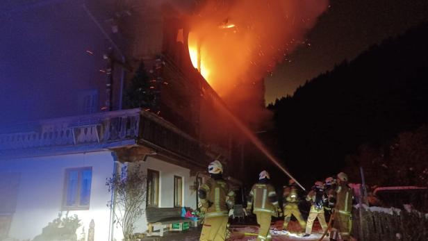 Feuerwehrleute bekämpfen einen Brand in einem Haus.