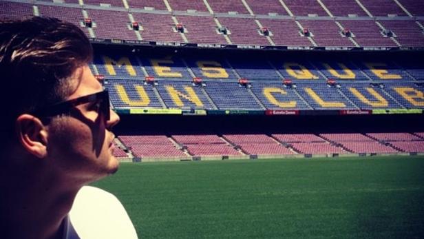 Ein Mann mit Sonnenbrille vor dem Camp Nou Stadion in Barcelona.