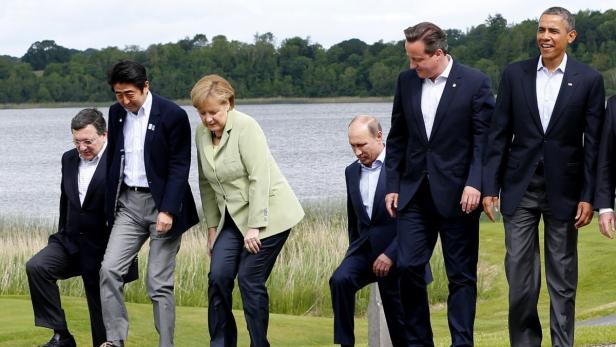 Britain&#039;s Prime Minister David Cameron (2nd R) arrives for a group photo with (L-R) European Commission President Jose Manuel Barroso, Japan&#039;s Prime Minister Shinzo Abe, German Chancellor Angela Merkel, Russia&#039;s President Vladimir Putin and U.S. President Barack Obama at the G8 Summit, at Lough Erne, near Enniskillen, in Northern Ireland June 18, 2013. REUTERS/Yves Herman (NORTHERN IRELAND - Tags: POLITICS)