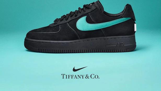 Ein schwarzer Nike Air Force 1 Schuh mit einem türkisfarbenen Tiffany & Co. Logo vor einem türkisfarbenen Hintergrund.