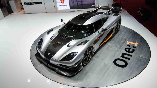 Ein silberner Koenigsegg One:1 Sportwagen auf einer Drehscheibe.