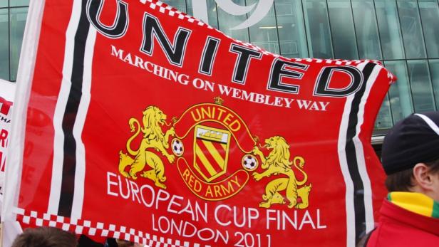 Eine rote Manchester United Flagge mit der Aufschrift „Marching on Wembley Way“.
