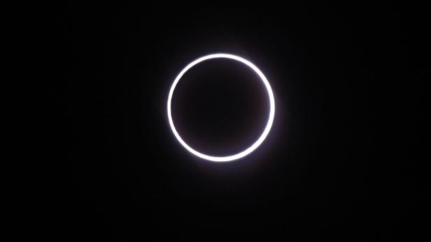 Eine ringförmige Sonnenfinsternis vor einem schwarzen Hintergrund.