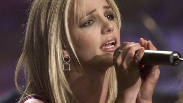 Britney Spears singt mit einem Mikrofon in der Hand.