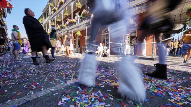 Konfetti und Perlen bedecken die Straße während einer Parade in New Orleans.