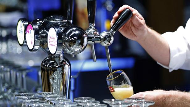 Ein Kellner zapft ein Glas Bier von Stella Artois.