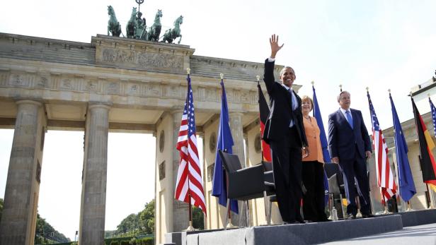 U.S. President Barack Obama waves as he arrives with German Chancellor Angela Merkel (2nd R) and Berlin Mayor Klaus Wowereit to give a speech in front of the Brandenburg Gate at Pariser Platz in Berlin June 19, 2013. Obama&#039;s first presidential visit to Berlin comes nearly 50 years to the day after John F. Kennedy landed in a divided Berlin at the height of the Cold War and told encircled westerners in the city &quot;Ich bin ein Berliner&quot;, a powerful signal that America would stand by them. REUTERS/Michael Kappeler/Pool (GERMANY - Tags: POLITICS)
