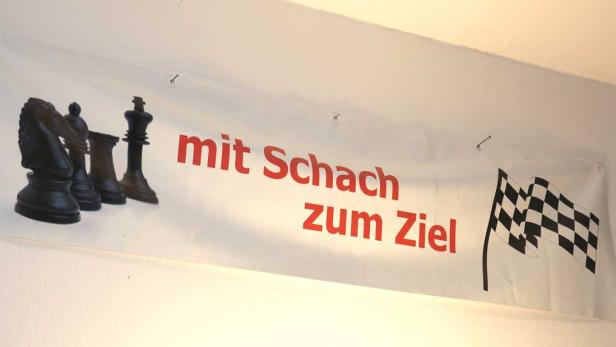 Ein Banner mit Schachfiguren, dem Text „mit Schach zum Ziel“ und einer Zielflagge.