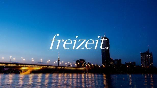 Die Skyline von Wien bei Nacht mit dem Schriftzug „freizeit.“ im Vordergrund.
