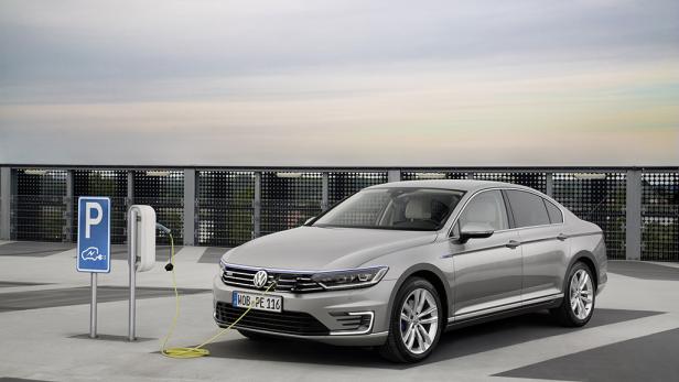 Ein silberner VW Passat steht an einer Ladestation für Elektroautos.