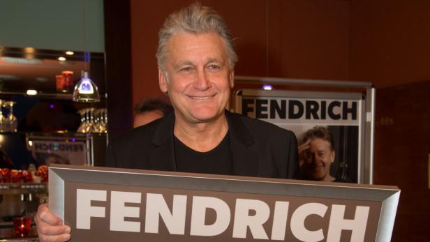 Christian Fendrich hält ein Schild mit seinem Nachnamen hoch.