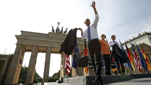 U.S. President Barack Obama waves after speaking in front of the Brandenburg Gate in Berlin, Germany June 19, 2013. With Obama are German Chancellor Angela Merkel and Berlin Mayor Klaus Wowereit. REUTERS/Kevin Lamarque (GERMANY - Tags: POLITICS)