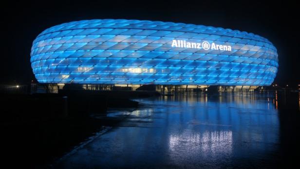 Die Allianz Arena in München leuchtet nachts blau.