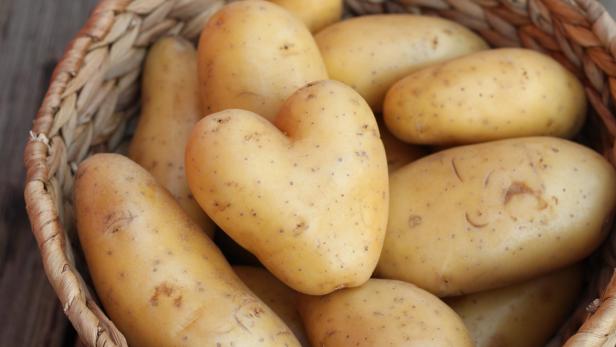 Kartoffeln in einem Korb, eine davon in Herzform.