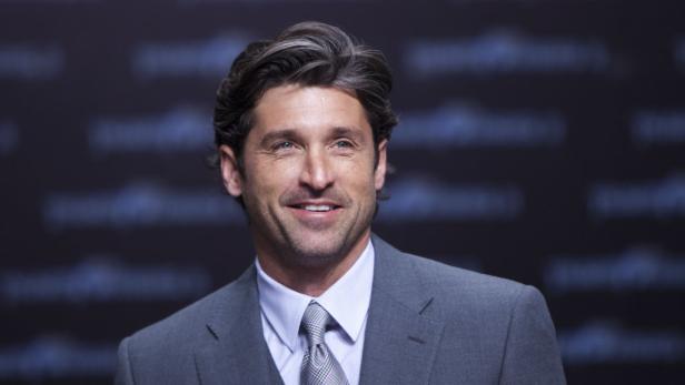 Patrick Dempsey lächelt in einem grauen Anzug.